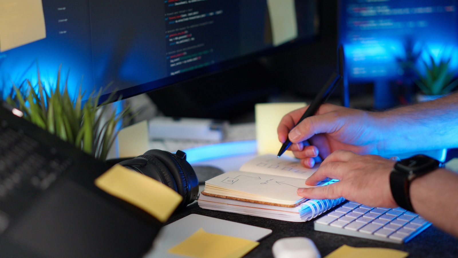 Person coding while taking notes representing common Team9 AI questions