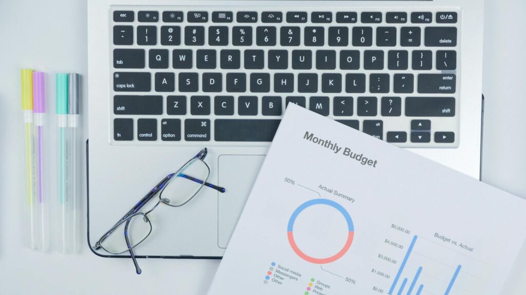 GeniLoop pricing and credit planning represented by a monthly budget summary on a desk.
