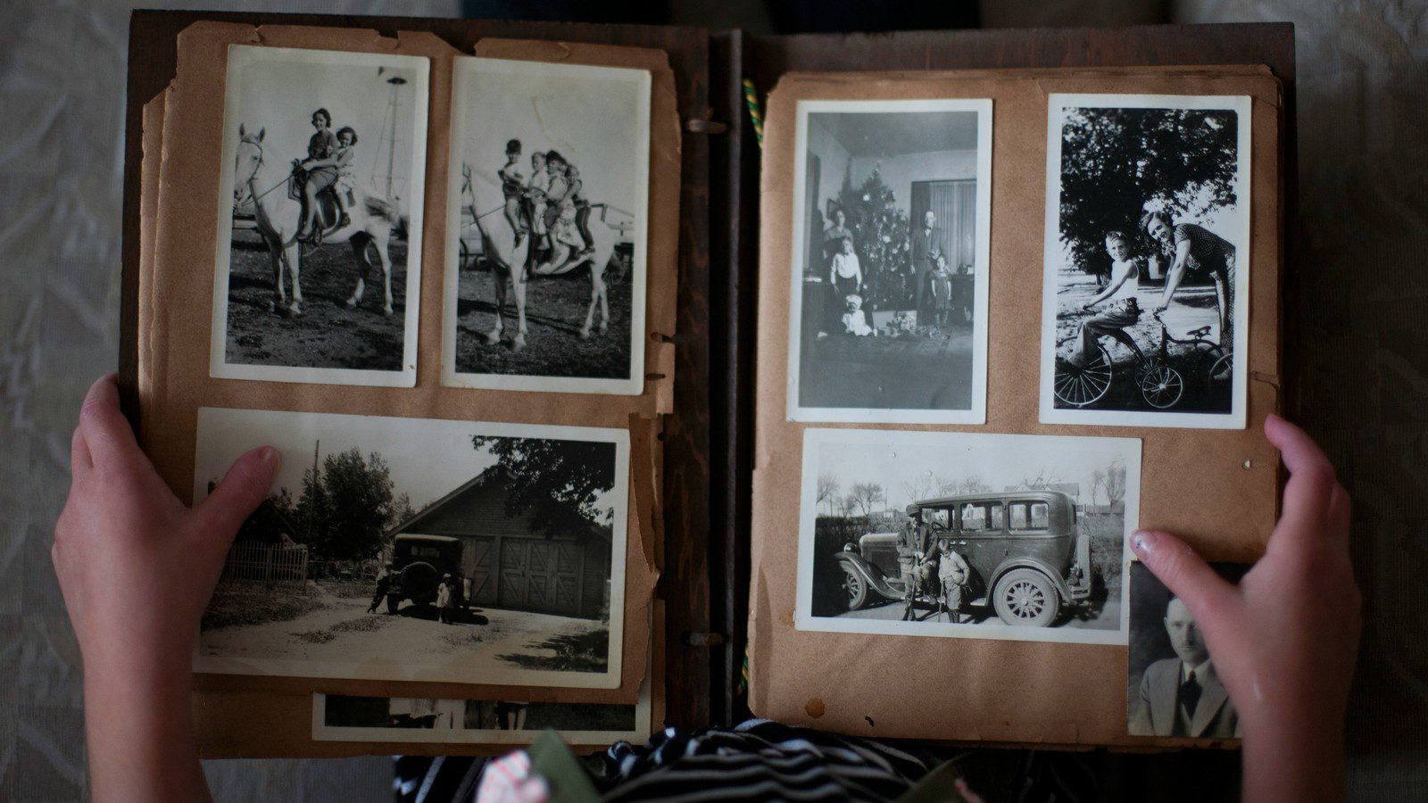 HitPaw Photo Restoration featured concept with a person opening a family photo album of grayscale pictures.