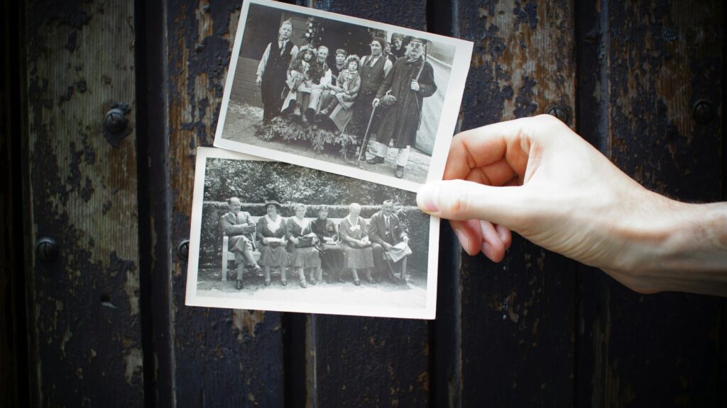 HitPaw Photo Restoration portrait recovery concept with a person holding vintage family photos.