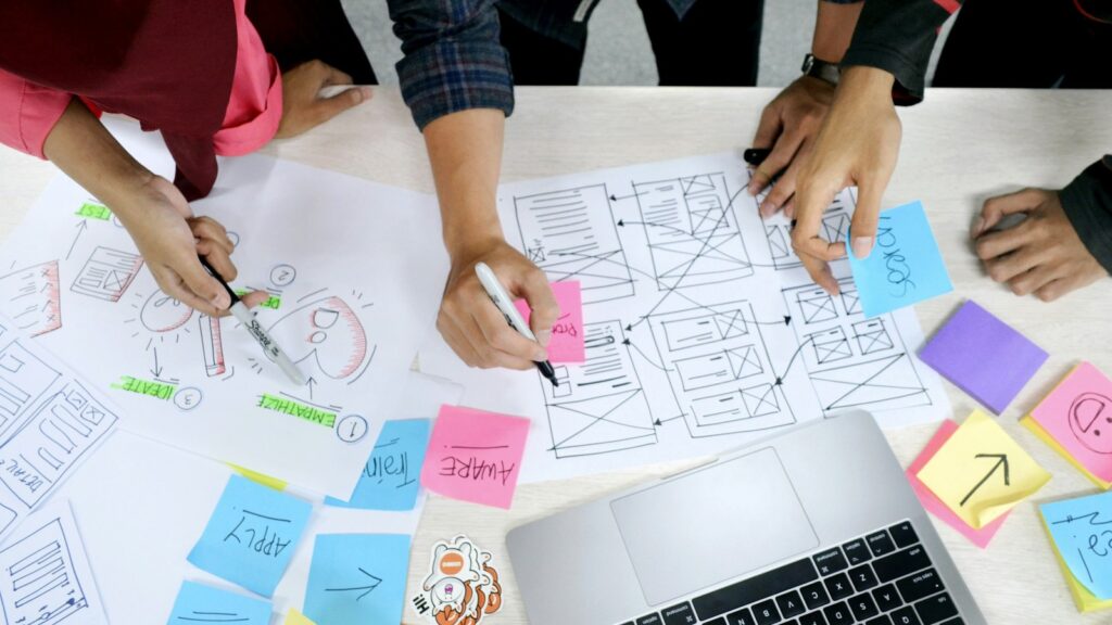 Person writing design research notes for an inclusive software workflow