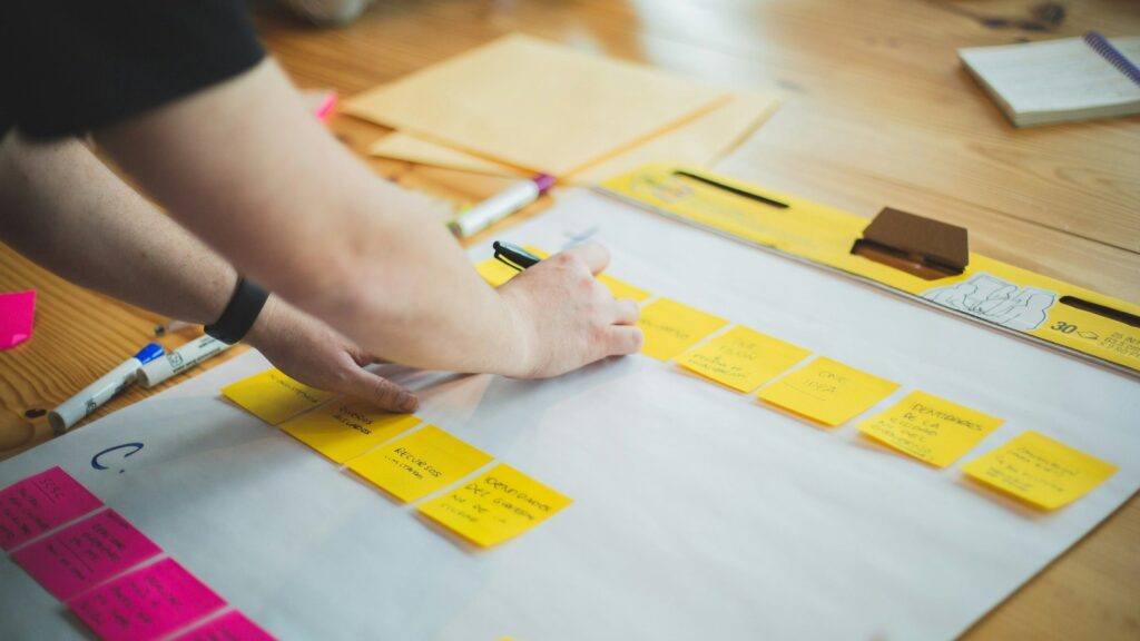 Person writing and sketching workflow notes for accessible form design