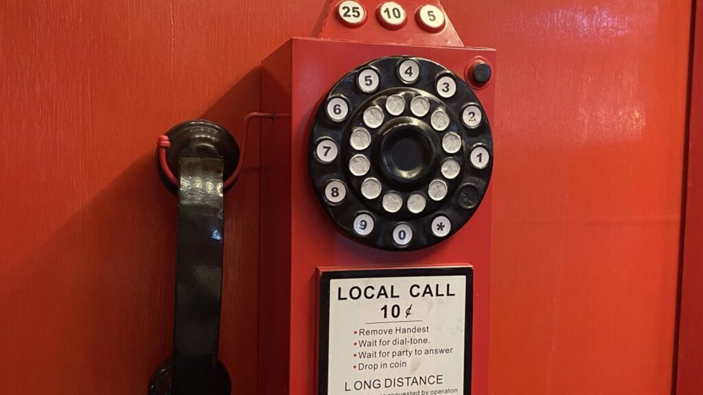 Post-PSTN Era red rotary payphone showing legacy telephony context