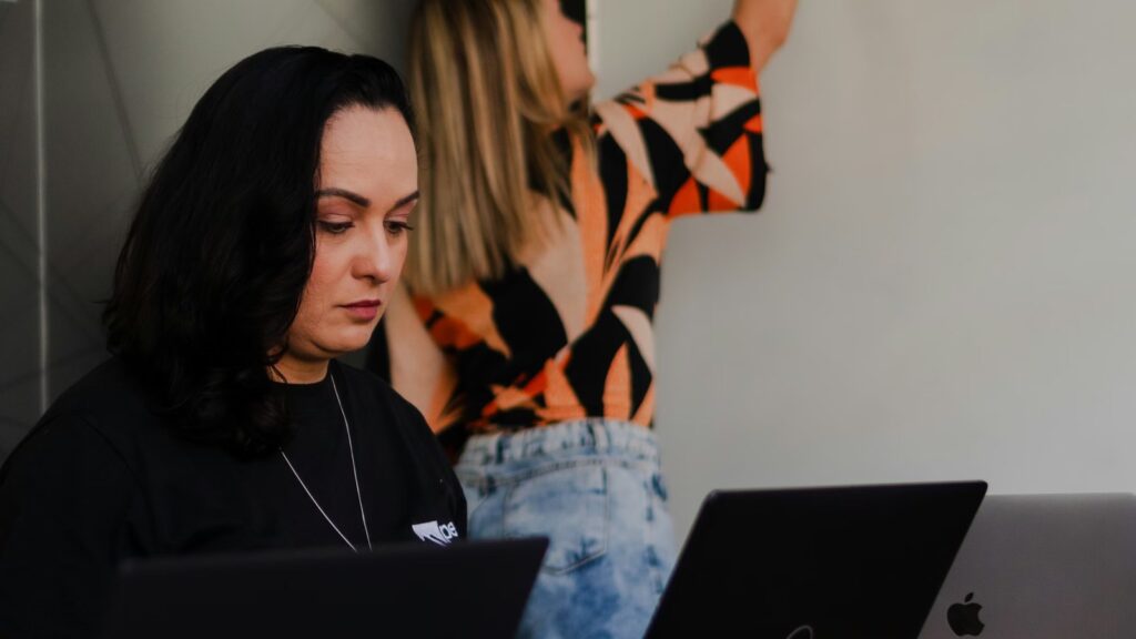 Two women working near a whiteboard during a planning session for Right to Disconnect boundaries