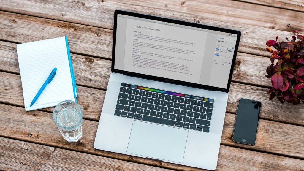 Laptop and phone on a desk representing Right to Disconnect controls for hybrid work