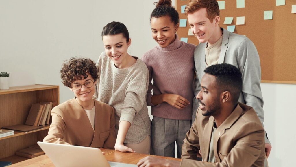 Team reviewing an office automation workflow around a laptop