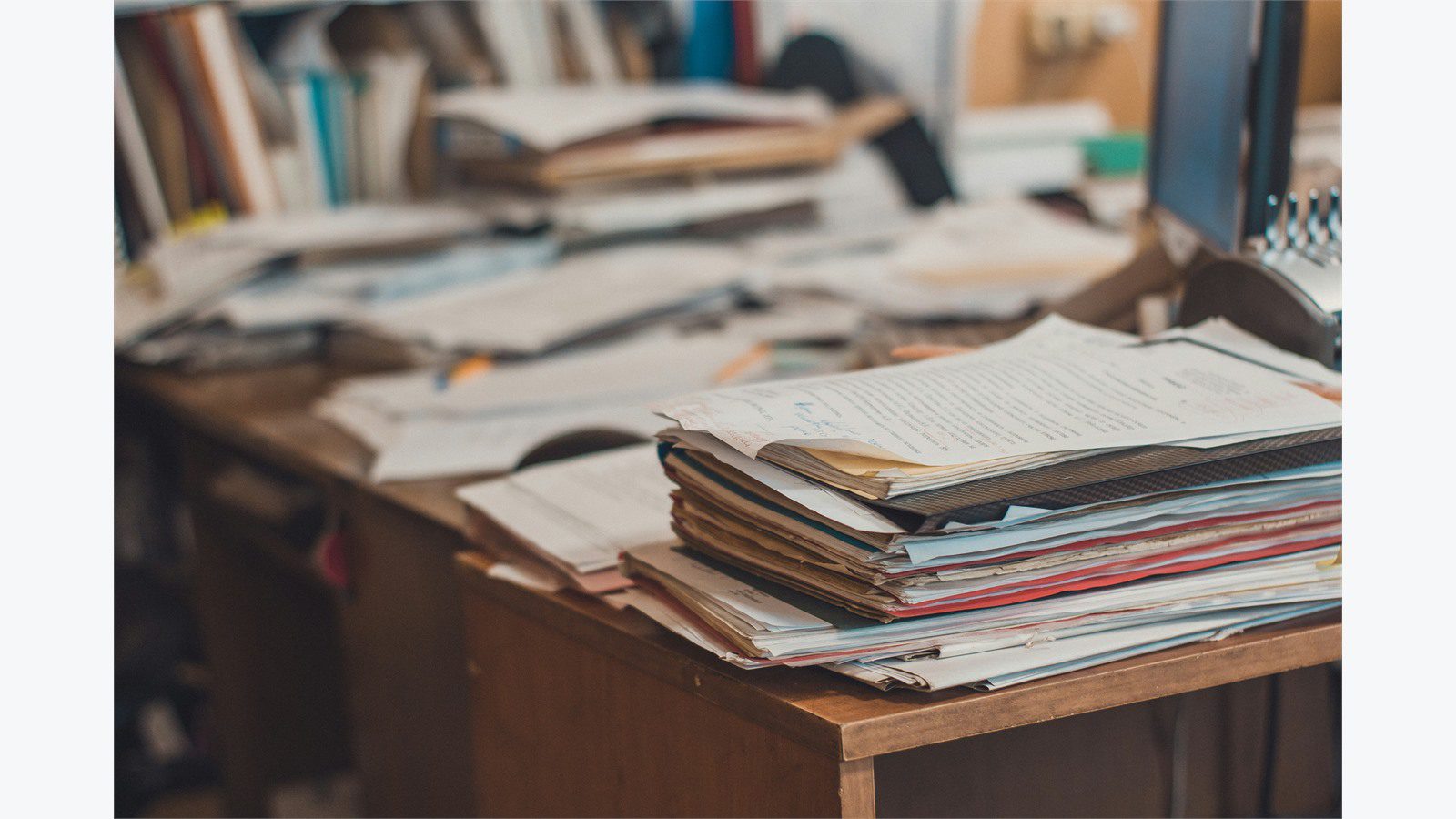 paper records stacked on office desk representing manual workarounds during minimum viable operations