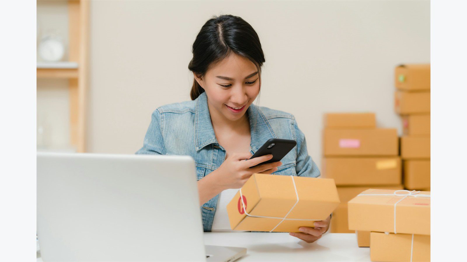 Custom Mobile ERP App: 7 Powerful Integration Steps 17 worker checking packages with phone near laptop and boxes for mobile ERP warehouse workflow design