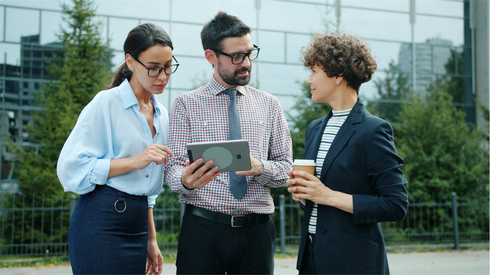Custom Mobile ERP App: 7 Powerful Integration Steps 21 custom mobile ERP app rollout planning with colleagues reviewing a tablet outside