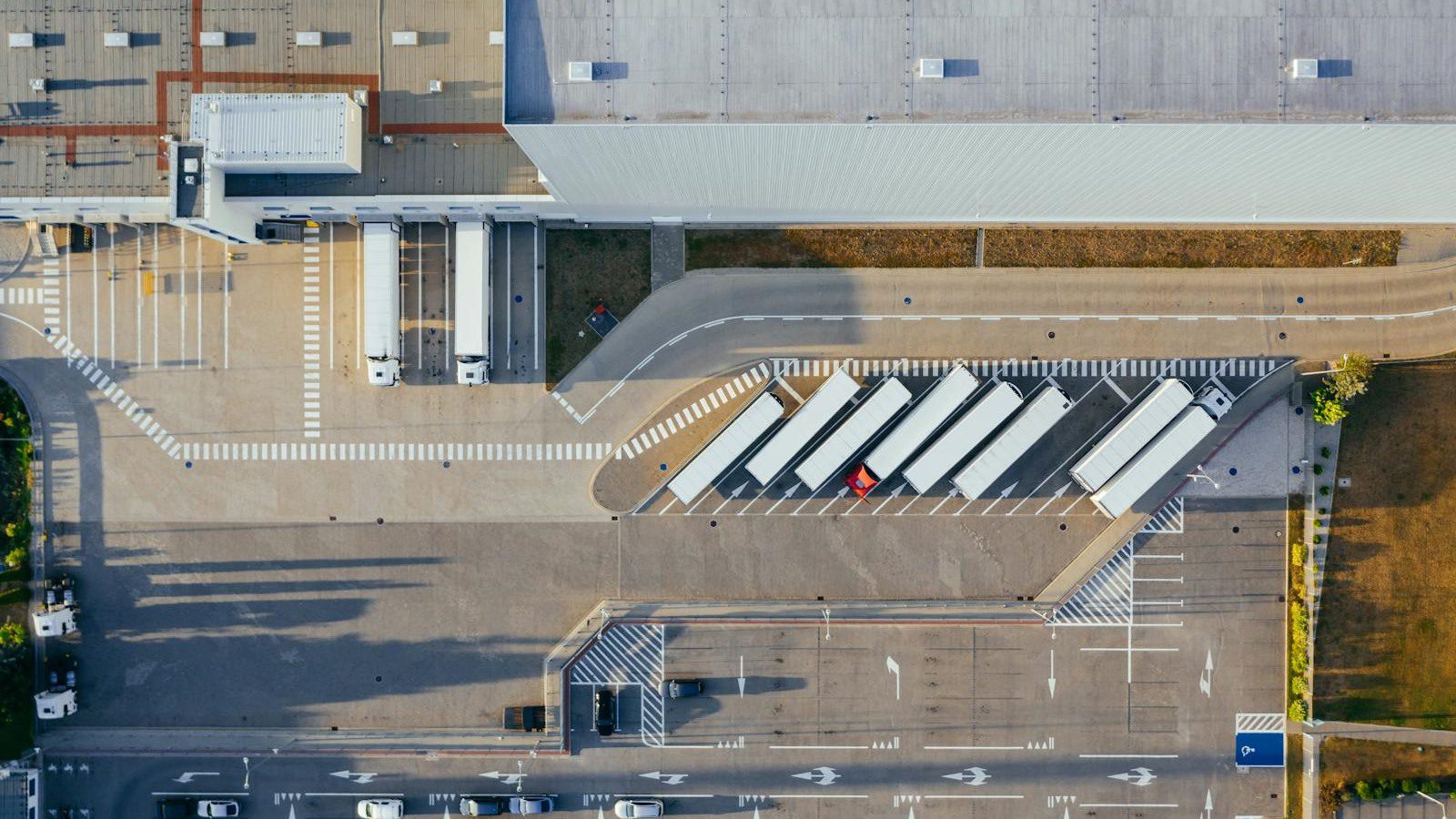 DLT Supply Chain Tracking: 7 Secure Wins Beyond Crypto 16 aerial logistics center with trucks representing automated supply chain exceptions and routing alerts