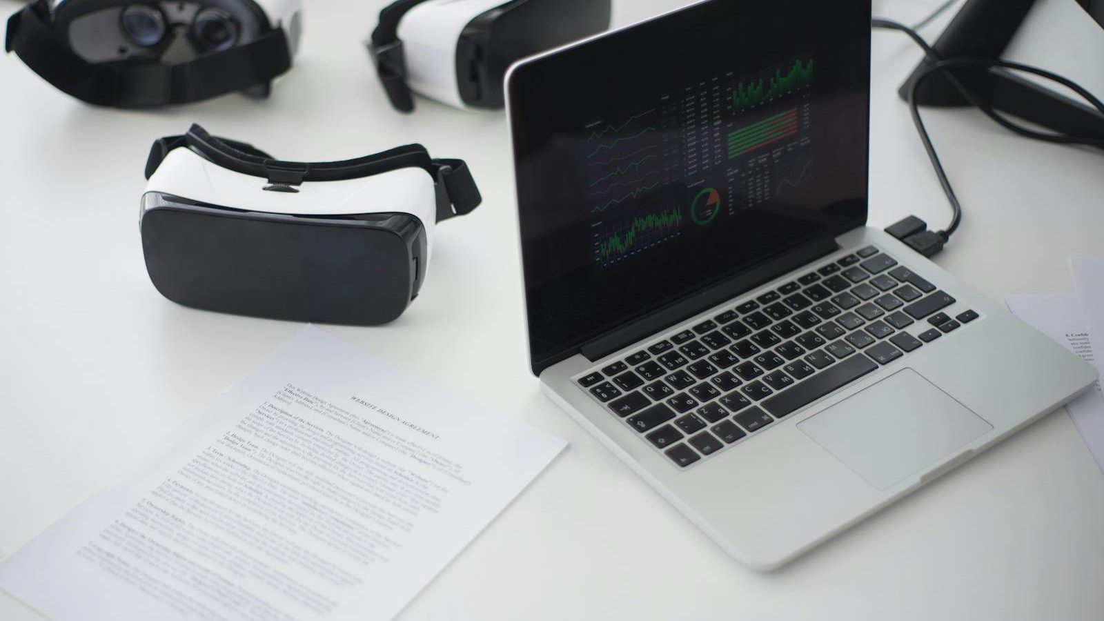 Extended Reality in Training: 7 Engaging Employee Wins 17 VR headsets and laptop on a workspace representing content and headset operations at scale