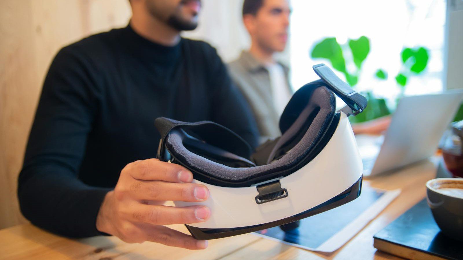 Extended Reality in Training: 7 Engaging Employee Wins 18 professional team reviewing a VR headset as part of an employee simulation rollout roadmap