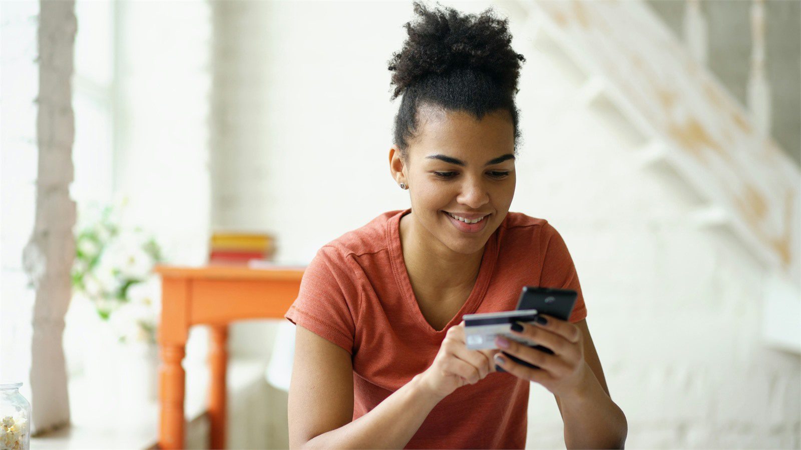 customer holding a phone and payment card representing transaction risk scoring and fraud controls