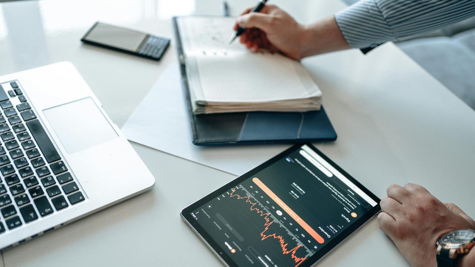business professional reviewing data trends on tablet and laptop for security controls