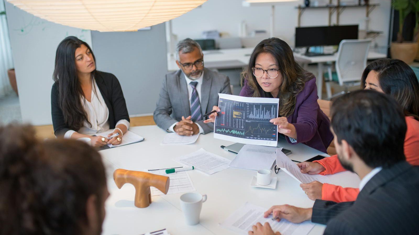 team discussing data charts during a business meeting for AI workflow rollout