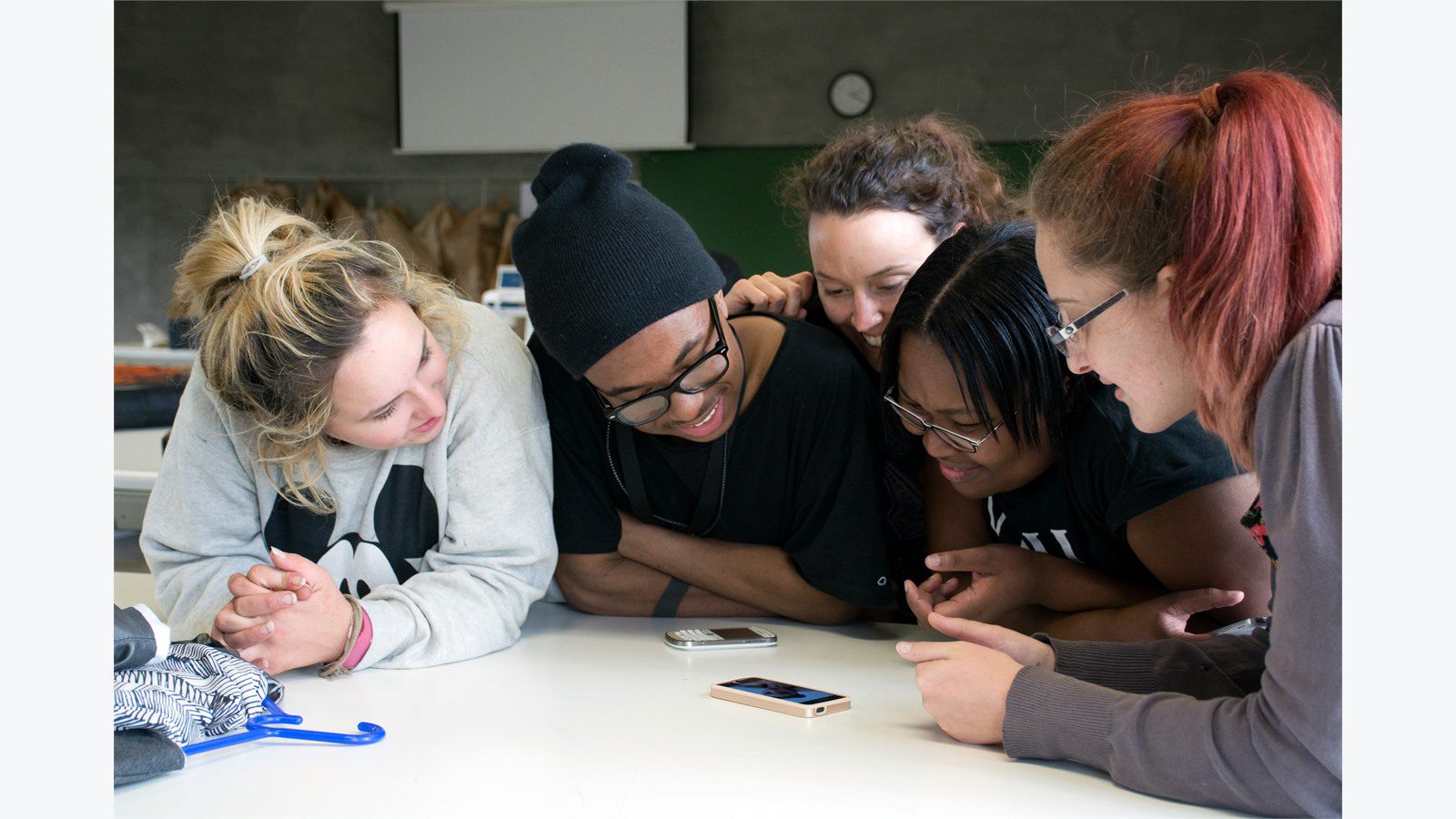 team gathered around a phone reviewing crisis communication messages before pressure rises