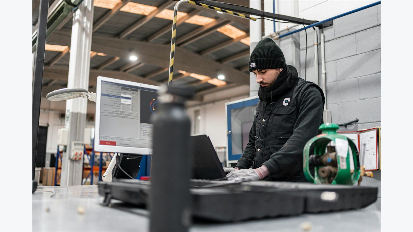IoT Sensors for Predictive Maintenance: 9 Powerful Wins 19 maintenance technician using a laptop beside equipment to manage work orders and CMMS tasks