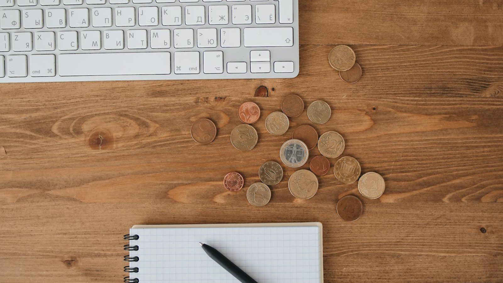 IT spending case study overview with coins keyboard and notebook for technology budget review