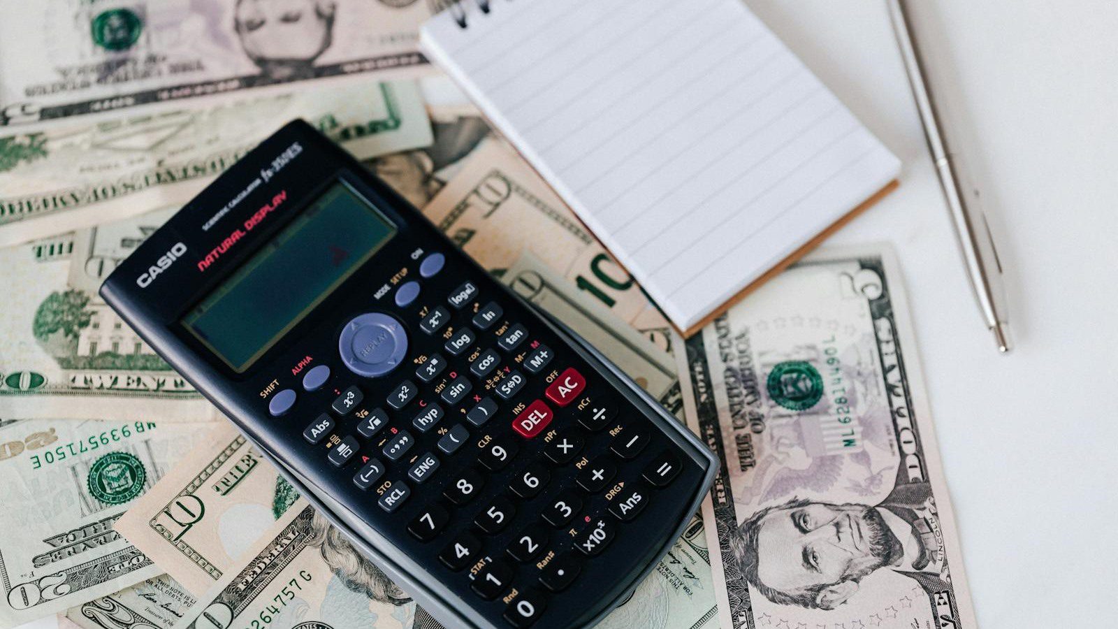 IT Spending Case Study: 7 Proven Ways We Cut Costs 30% 15 calculator and notepad on dollars representing vendor contract and support tier renegotiation