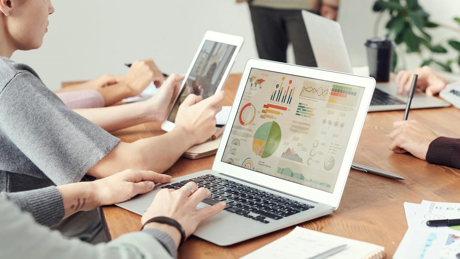 Outgrown IT Setup? 10 Warning Signs to Fix Fast 11 business team reviewing charts and laptop data for IT cost growth and technology strategy decisions