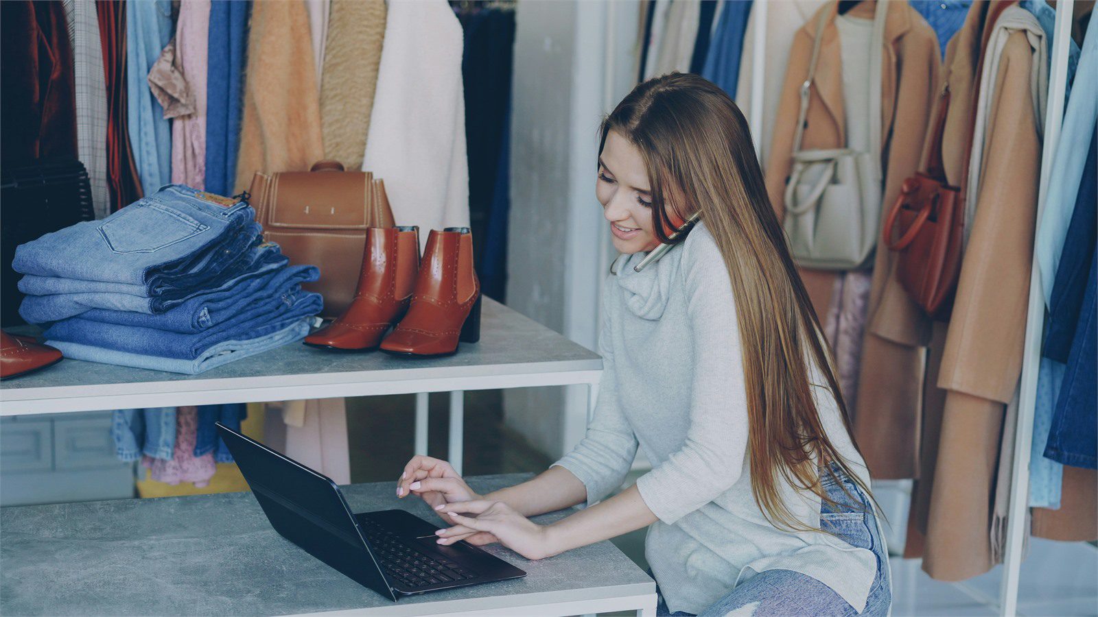 Retail Cyber Theft: 7 Proven Defenses for Local Stores 11 store owner using a laptop in a clothing shop to manage accounts and reduce retail cyber theft