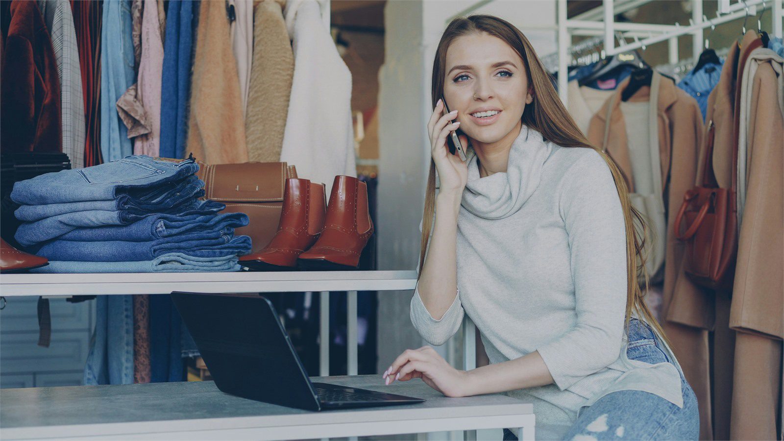 Retail Cyber Theft: 7 Proven Defenses for Local Stores 12 retail employee using a phone and laptop in a shop for staff training against scams and refund abuse