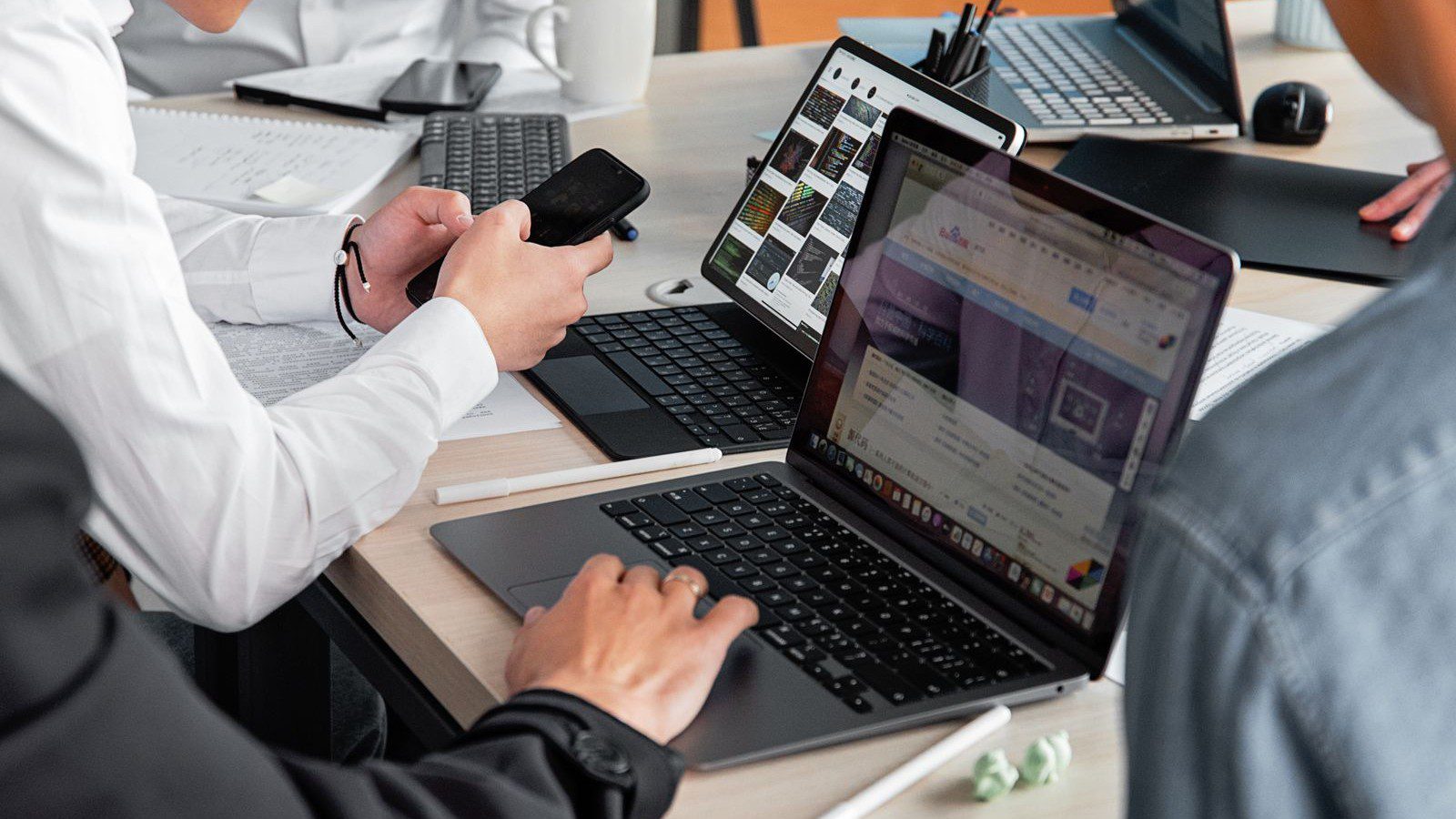 unified endpoint management consulting services: executives and staff reviewing corporate mobile devices and laptops
