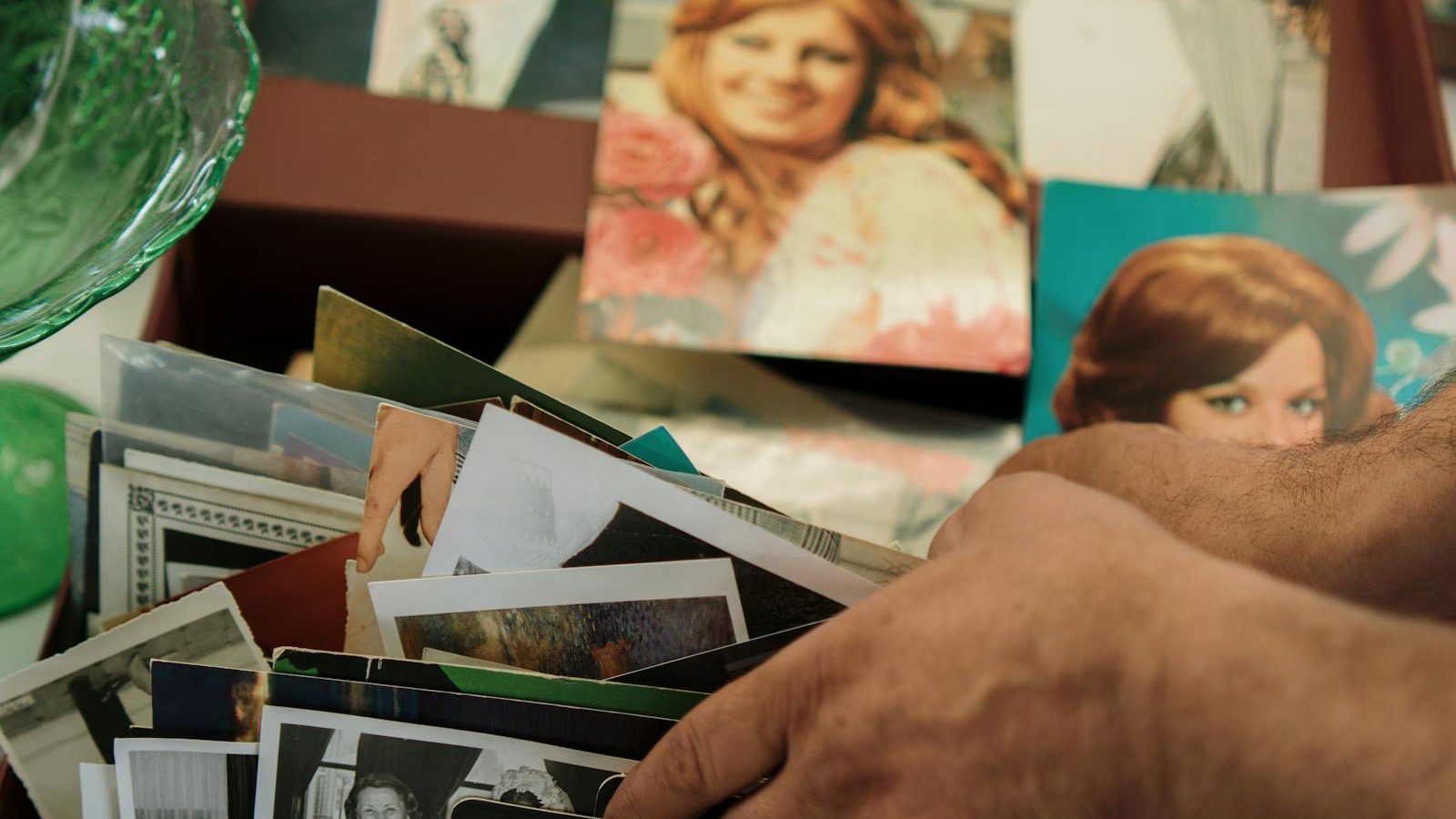 Vimi FAQ with hands sorting vintage photos for AI photo to video questions