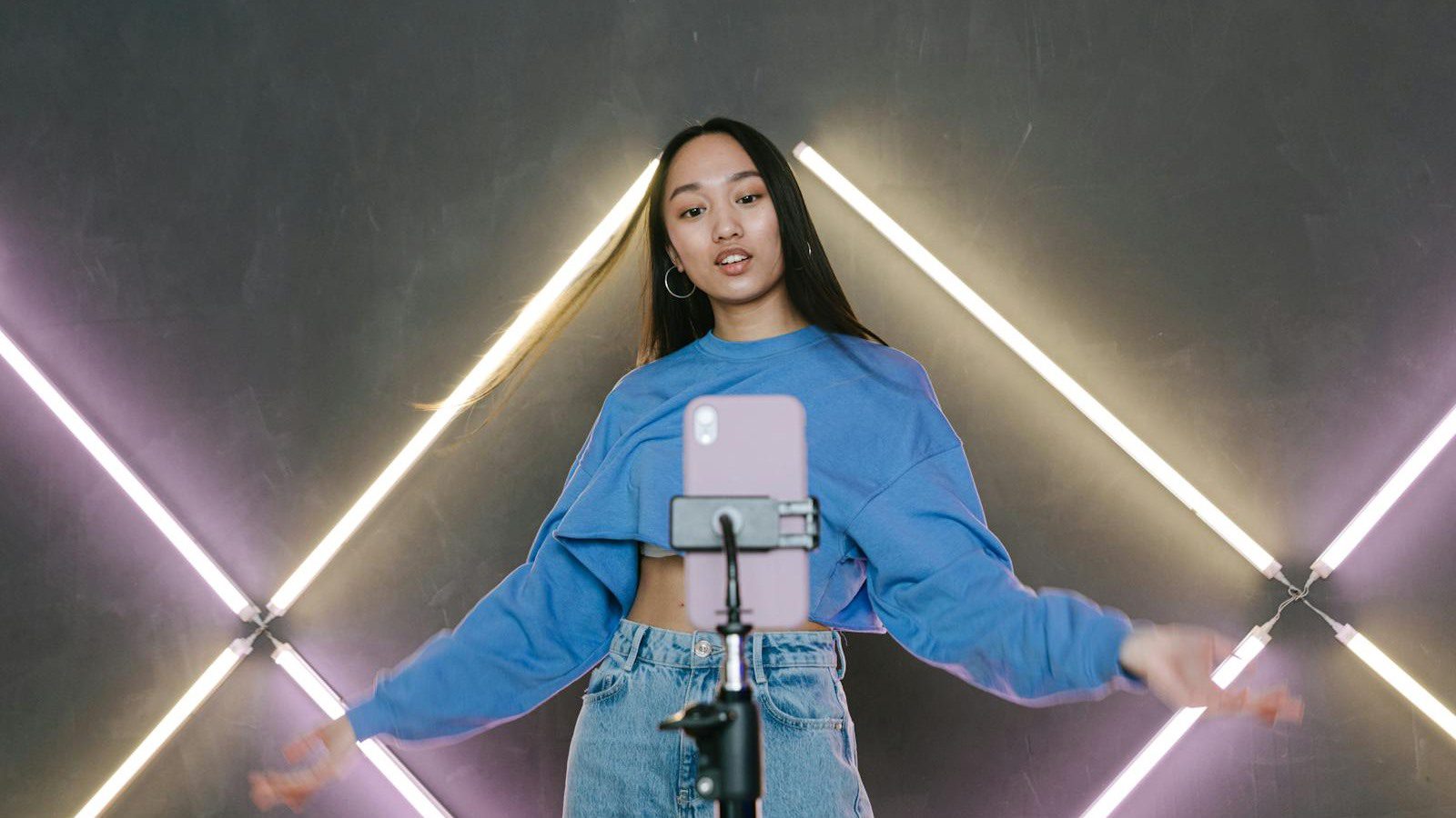 content creator using smartphone and ring light representing social ready templates and effects