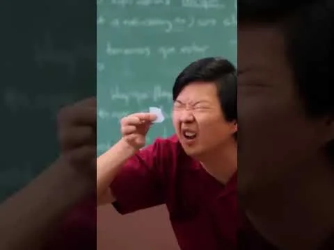 progressive Robot person squinting while holding a small slip of paper in front of a chalkboard with writing