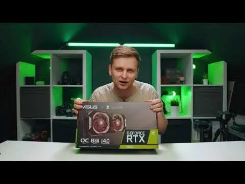 Progressive Robot presenting an ASUS GeForce RTX graphics card box at a desk with green-lit shelves behind him