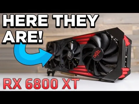 Progressive Robot: graphics card with “HERE THEY ARE!” text and arrow pointing to RX 6800 XT on a table