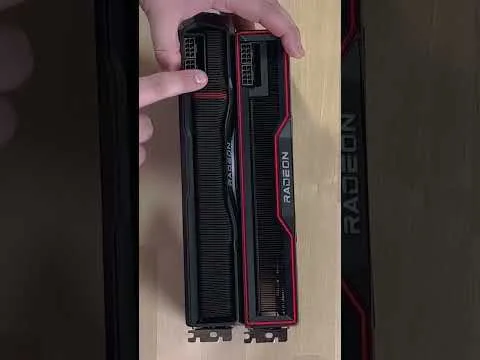 progressive Robot hands holding two Radeon graphics cards side by side on a wooden surface