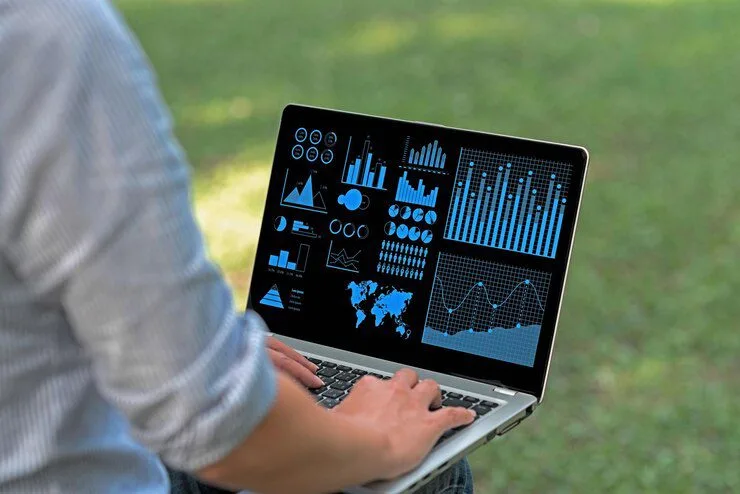Benefits of Using Apache Superset as a Data Visualization and Data Exploration Platform 14 Progressive Robot' person using a laptop displaying analytics dashboards with charts and graphs outdoors