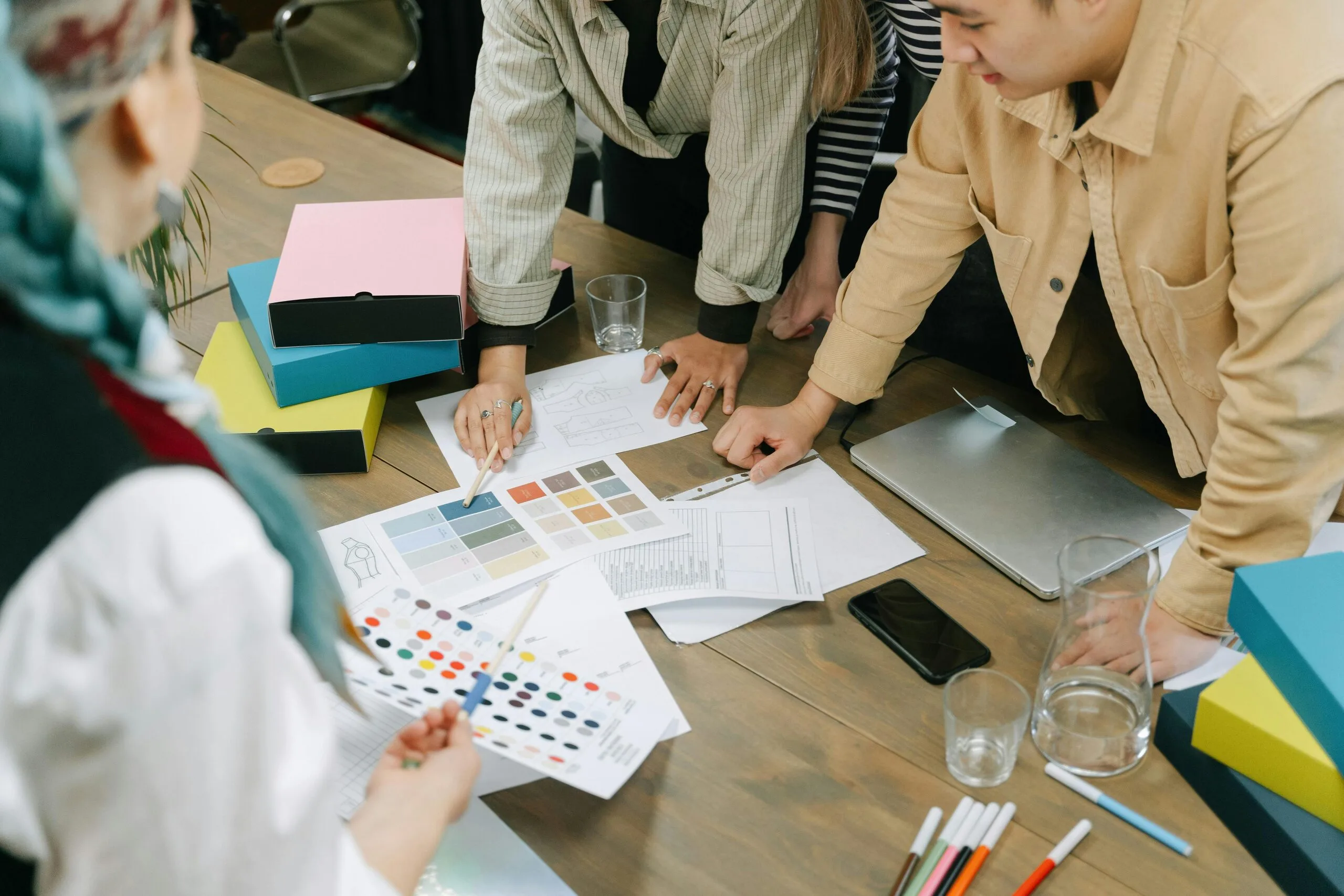 Anthropic launches Claude Design illustrated as a design team reviewing visual concepts and color samples