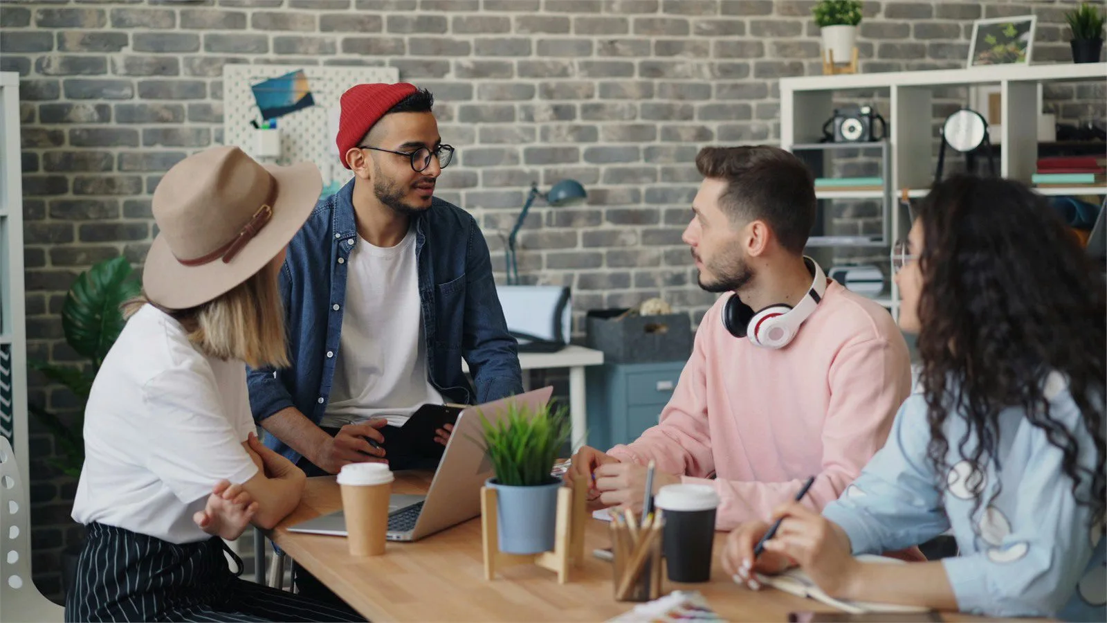 AdsCreator.com concept with a marketing team reviewing ad creative ideas around a laptop