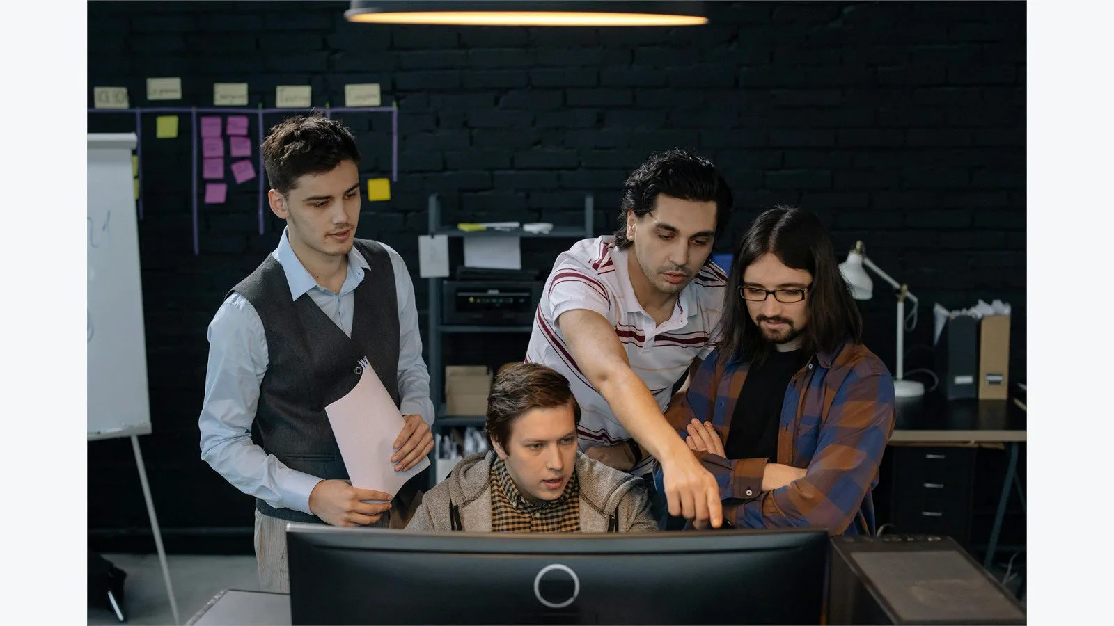 AngularJS End of Life in 2026: 7 Smart Moves for Legacy Apps 17 Team discussing code questions at a shared workstation during a legacy app review