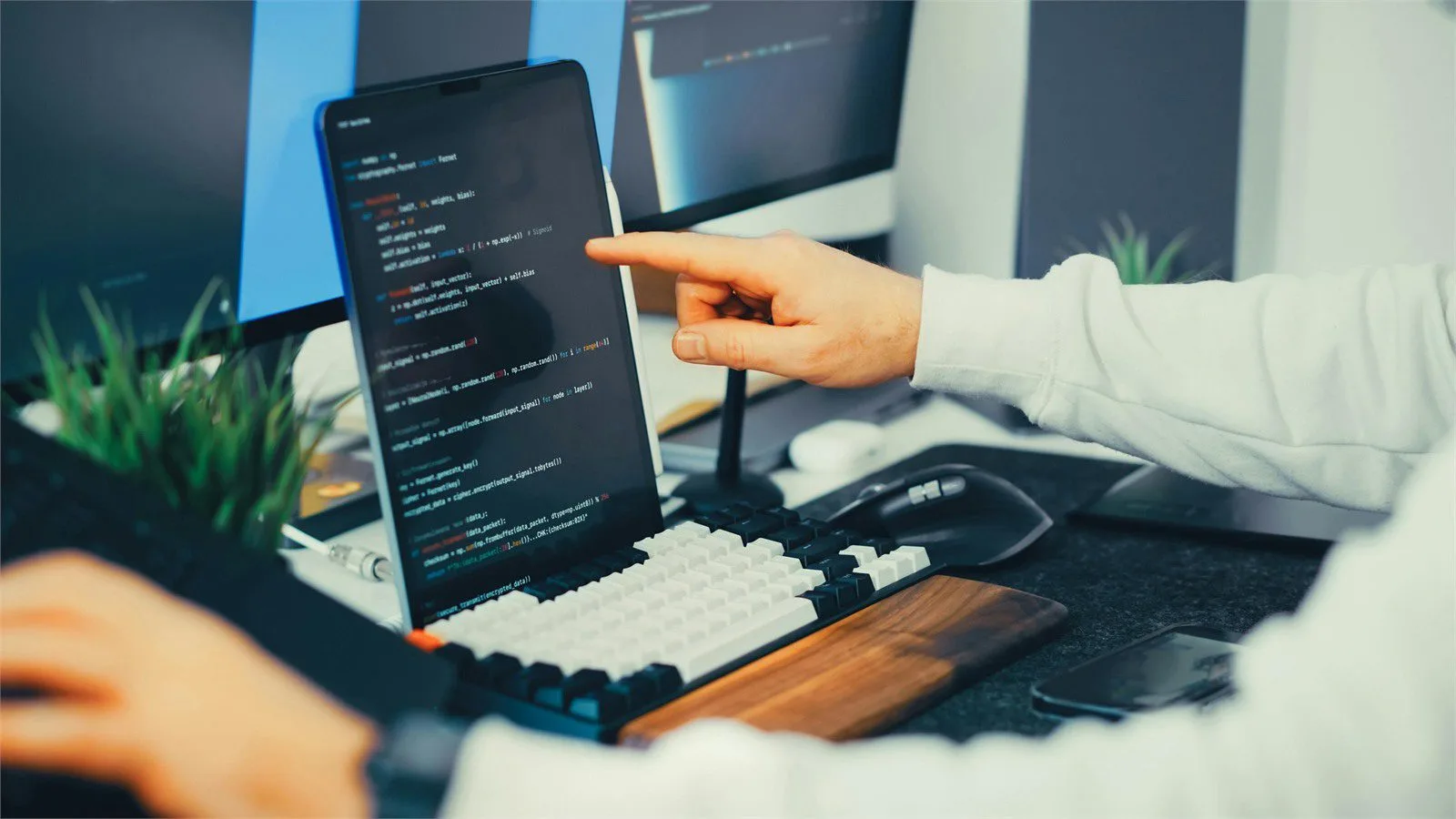Developer debugging Java code across a laptop and monitor during async test review