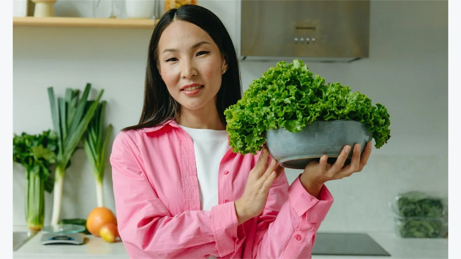 CalBye Review: 9 Smart Features for Better Nutrition 16 CalBye user fit concept with a person holding lettuce in a wide kitchen scene