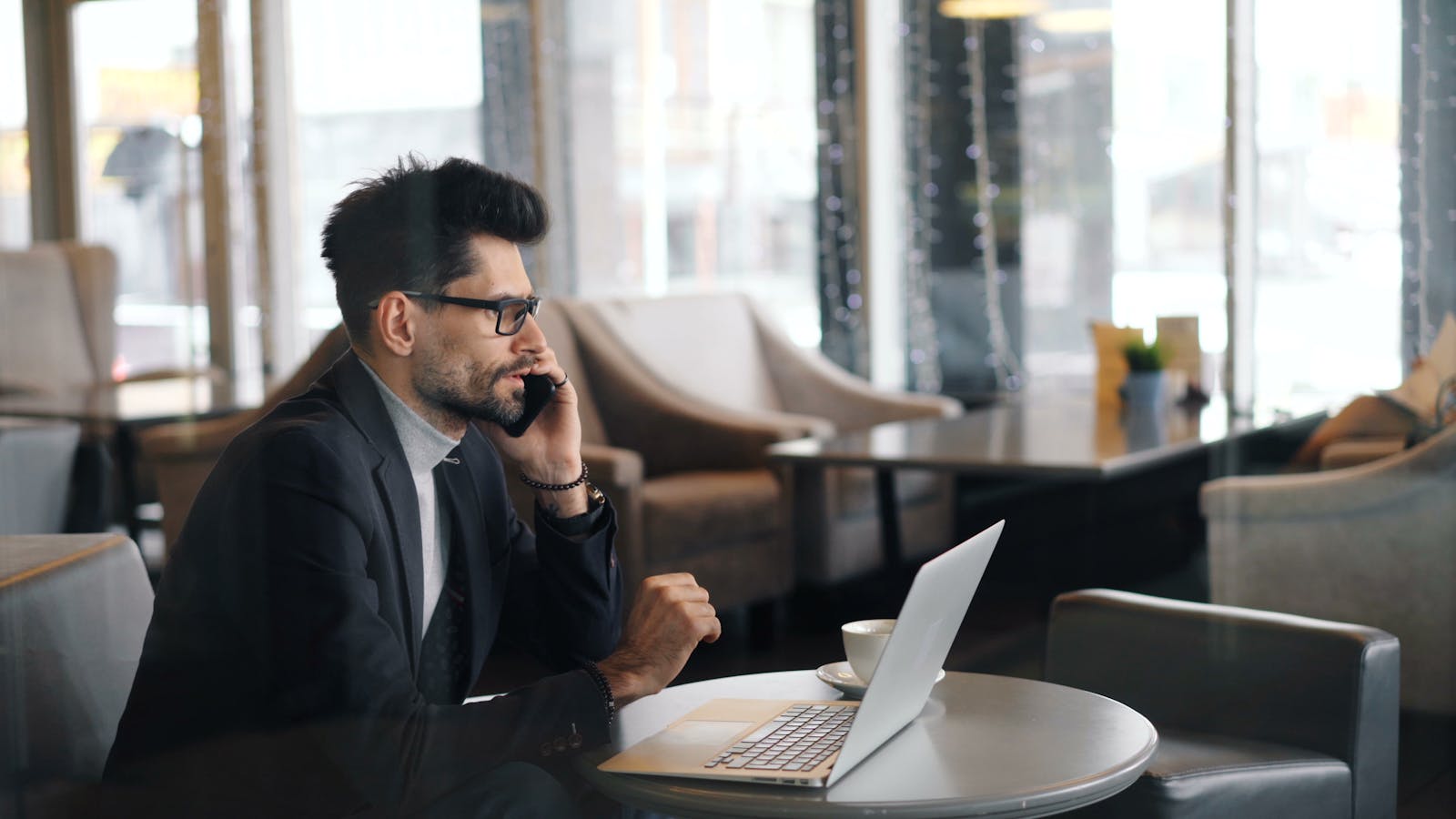 Executive using phone and laptop as teams protect voice and video likeness from impersonation