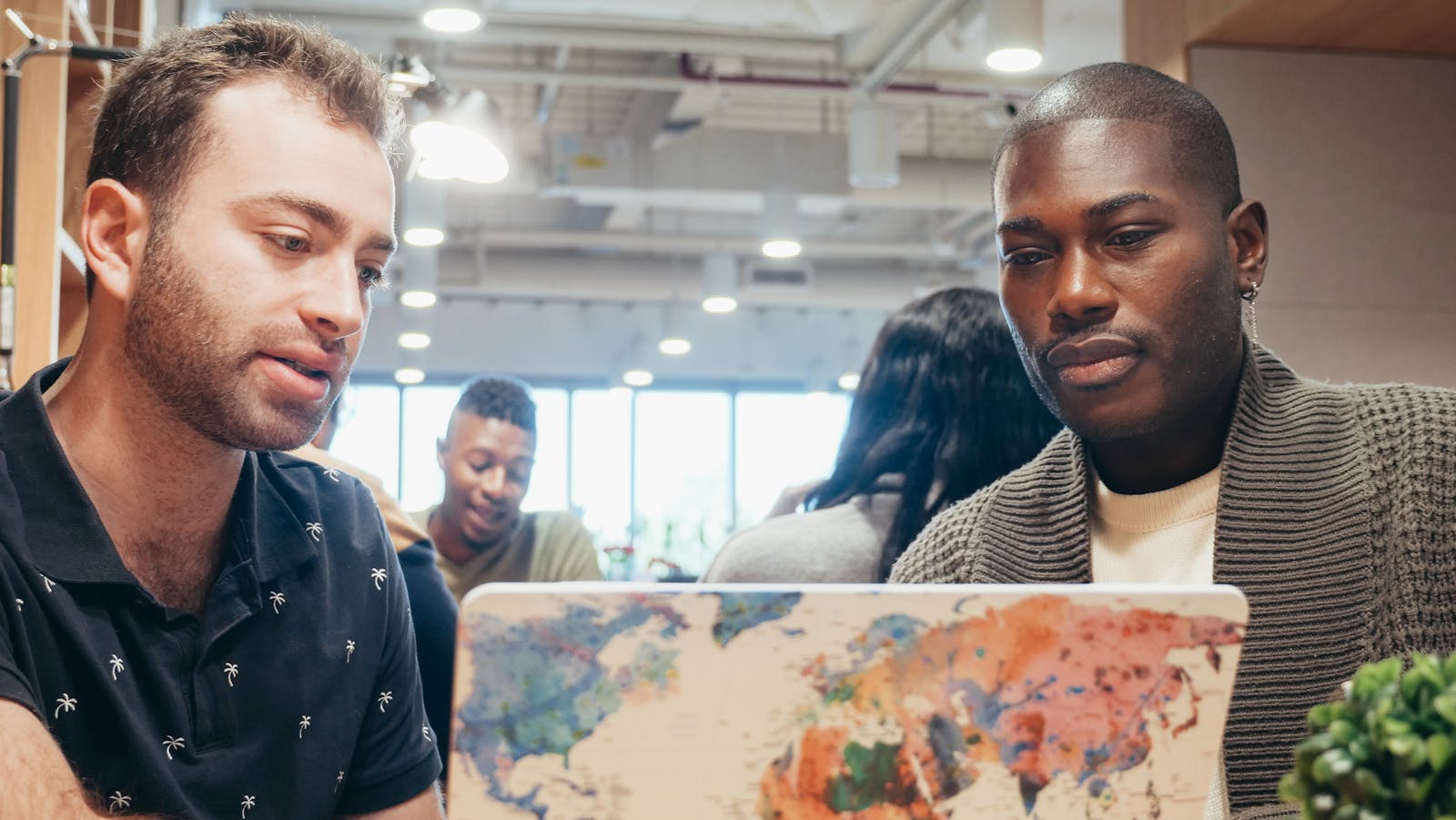 Zero-Touch IT: 8 Powerful Ways to Cut Helpdesk Load 13 IT support team collaborating on a laptop as autonomous agents handle routine tickets