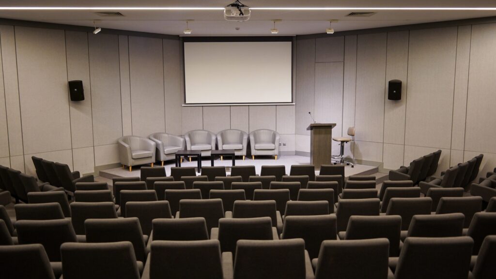 GPT-Realtime-2 Voice Agents enterprise rollout shown by a conference room with podium microphone