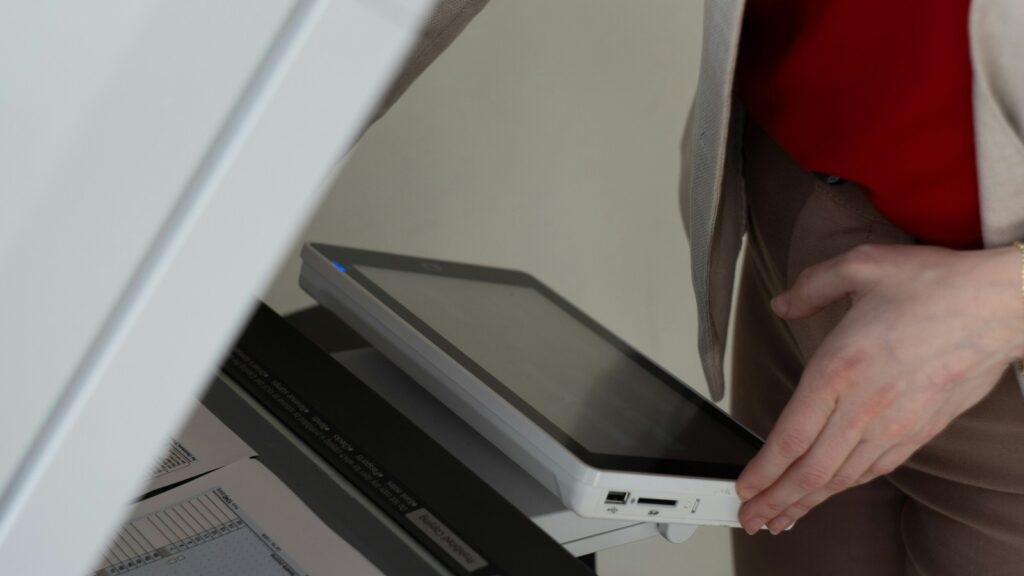 HitPaw Photo Restoration scan workflow represented by a person using a scanner in an office.