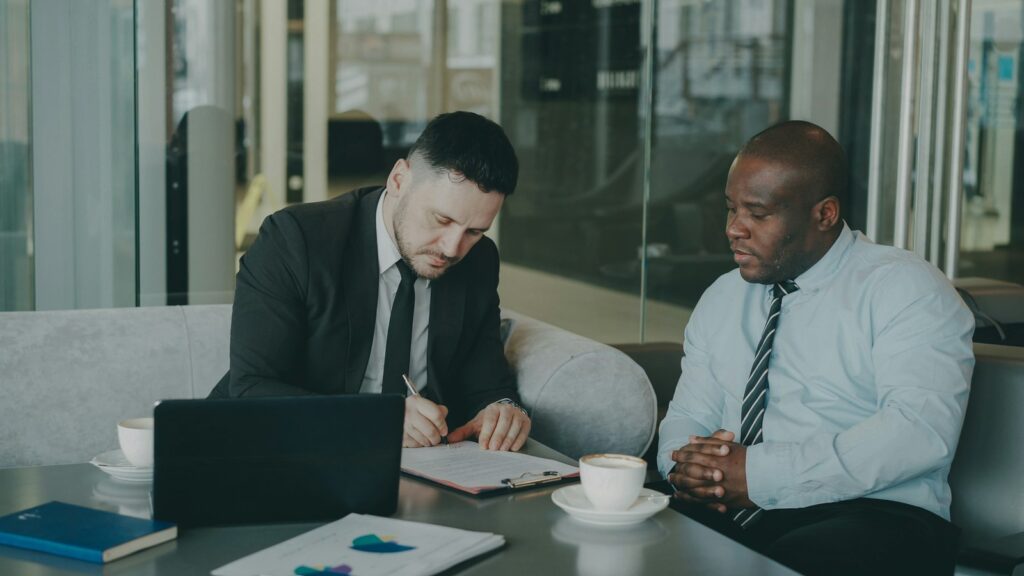 Two professionals reviewing and signing a document as a legal-office Li-Fi security use case